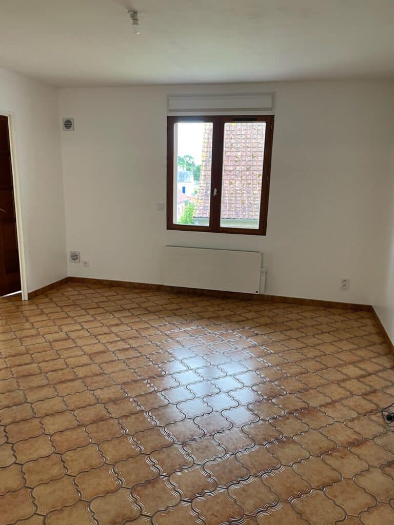 Pièce lumineuse du pavillon à Saint Léger les Domart avec carrelage rétro, fenêtre en bois et radiateur mural. Rafraîchissement d'un pavillon