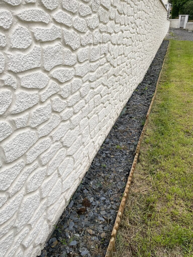 Mur extérieur du pavillon à Saint Léger les Domart en crépi imitation pierre blanche avec bordure en ardoise