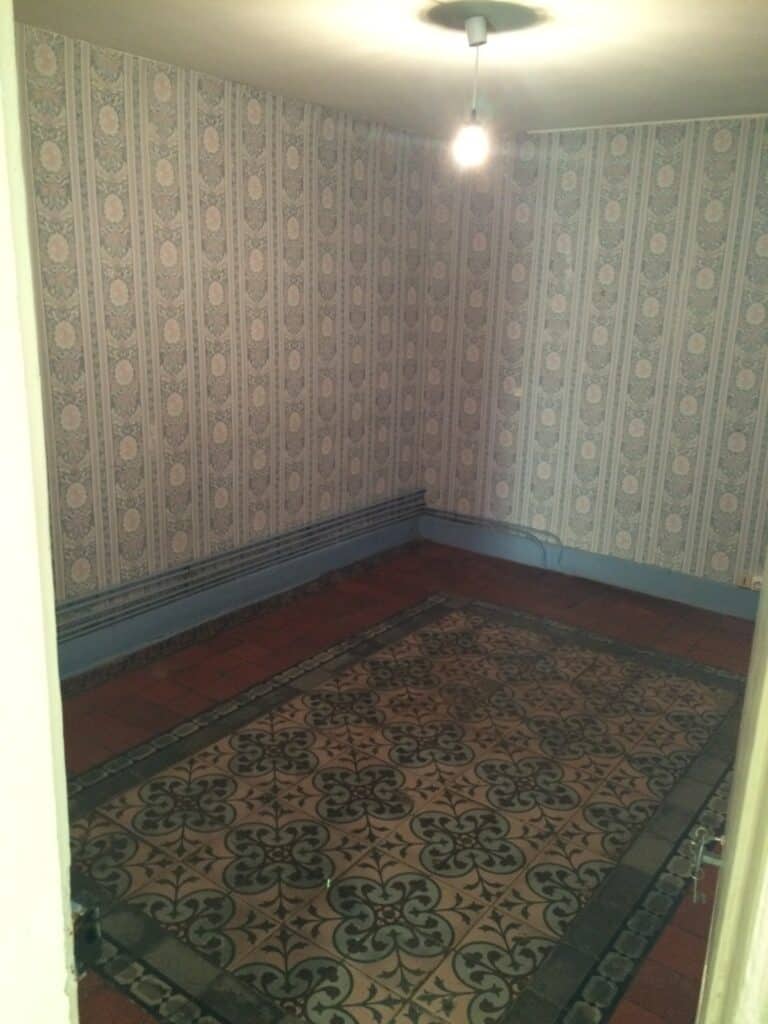 Chambre avec sol carrelé et papier peint floral dans une maison à Moreuil avant travaux