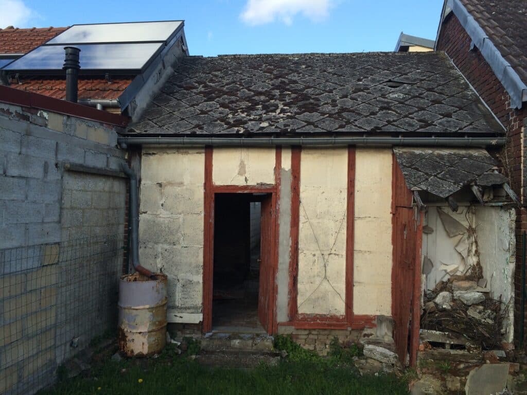 Façade arrière de la maison de ville à Moreuil avec murs abîmés et toiture en mauvais état