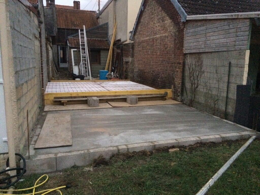 Fondations en cours de construction dans la maison de ville à Moreuil, avec matériaux et équipements sur place